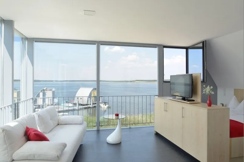 Wohnbereich des Appartements Seeblick mit bodentiefen Fenstern zum See
